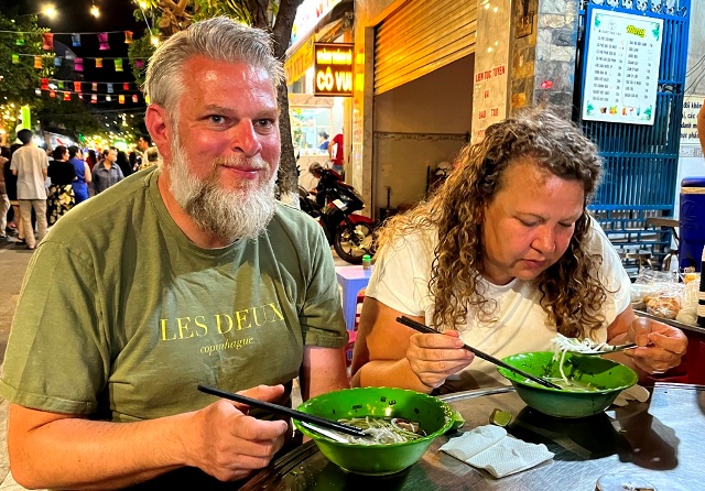 (Du khách Đan Mạch thưởng thức Bánh canh chả cá; Ảnh: Nguyên Vũ)